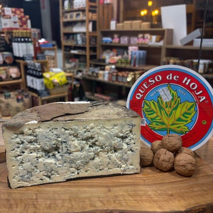 Queso azul de hoja con su etiqueta, envuelto en hojas naturales